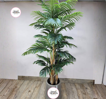 Artificial Areca (2.5m) Plants UAE. Artificial palm tree in a pot on a wooden floor with a white wall background.