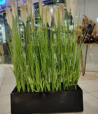 Artificial Plant Grass in Rectangle Pot Plants UAE. Artificial grass in a black planter with a store interior background