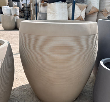 Fiber Luna Patterned Pots Lifetime Warranty in the UAE. Beige outdoor chair with textured surface on a concrete floor
