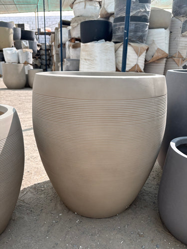Fiber Luna Patterned Pots Lifetime Warranty in the UAE. Beige outdoor chair with textured surface on a concrete floor
