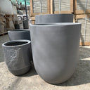 Fiber Pot Aura Grey Lifetime Warranty in the UAE. Metal pipes stacked outdoors on a concrete surface