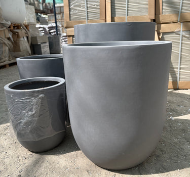 Fiber Pot Aura Grey Lifetime Warranty in the UAE. Metal pipes stacked outdoors on a concrete surface