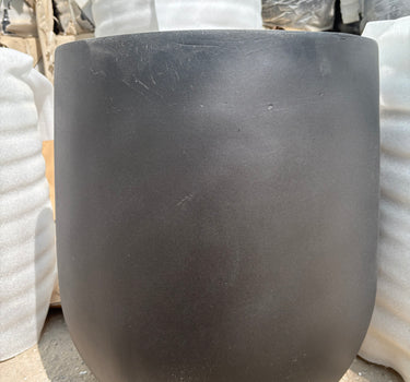 Long Lifetime Warranty Fiber Pot – Available in White, Yellow, Beige & Grey, UAE. Close-up of a black rubber hose on a concrete surface with white pipes in the background. 